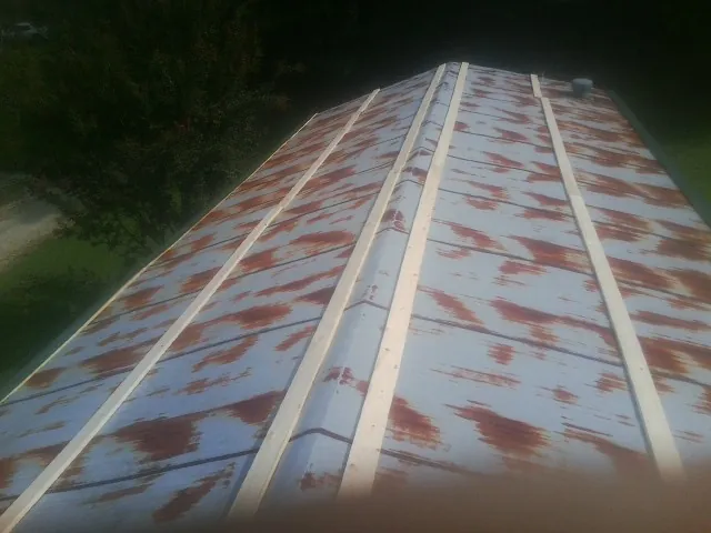 Rusted metal roof panels with new wood purlins before replacement — Storm Damage Roof Repair in Worthington by Roofing Brothers
